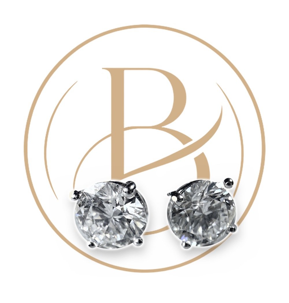 Round diamond studs, 2 × 1.03 ct, in 14k white gold, in front of the BAZANA monogram